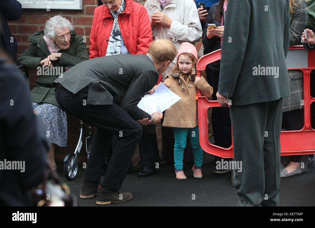 Il principe Harry viene tratto da una bambina (nome non noto) mentre parte dopo la sua visita alla sala del villaggio di St Michael's sul Wyre nel Lancashire, in seguito alla sua visita al villaggio colpito dalle inondazioni nel febbraio 2016. Foto Stock
