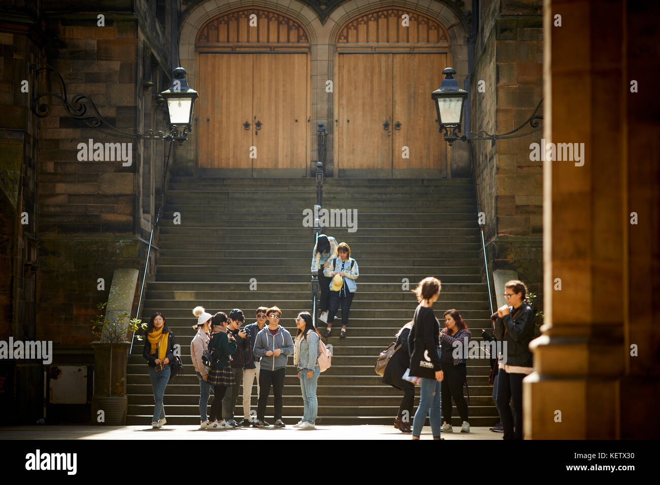 La Scozia, New College dell Università di Edimburgo facoltà di divinità cortile come turisti esplorano le scale Foto Stock