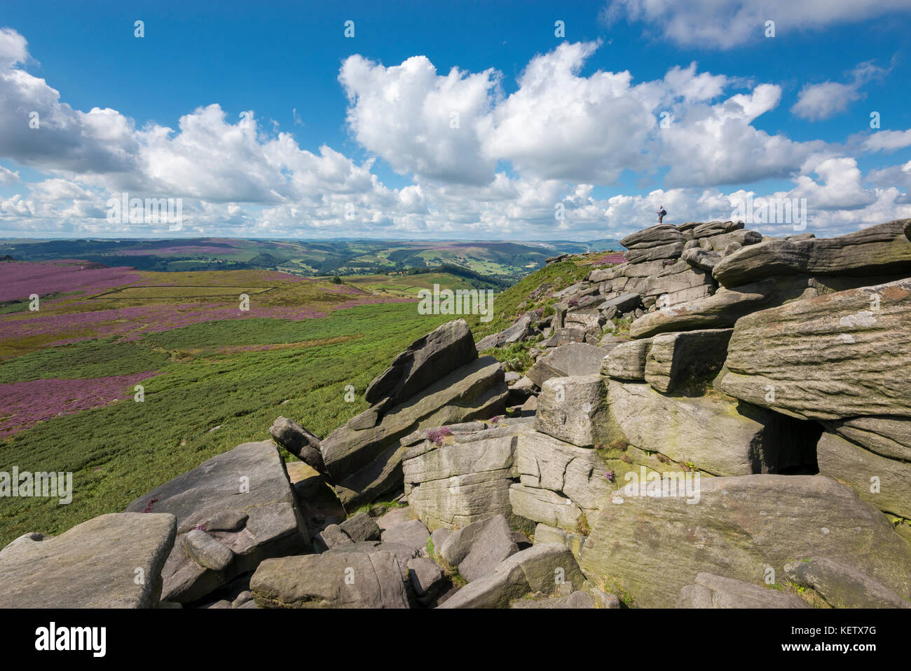 Il turista si trovava sulle rocce a Higger Tor vicino a Hathersage nel parco nazionale del Peak District, Derbyshire, Inghilterra. Foto Stock