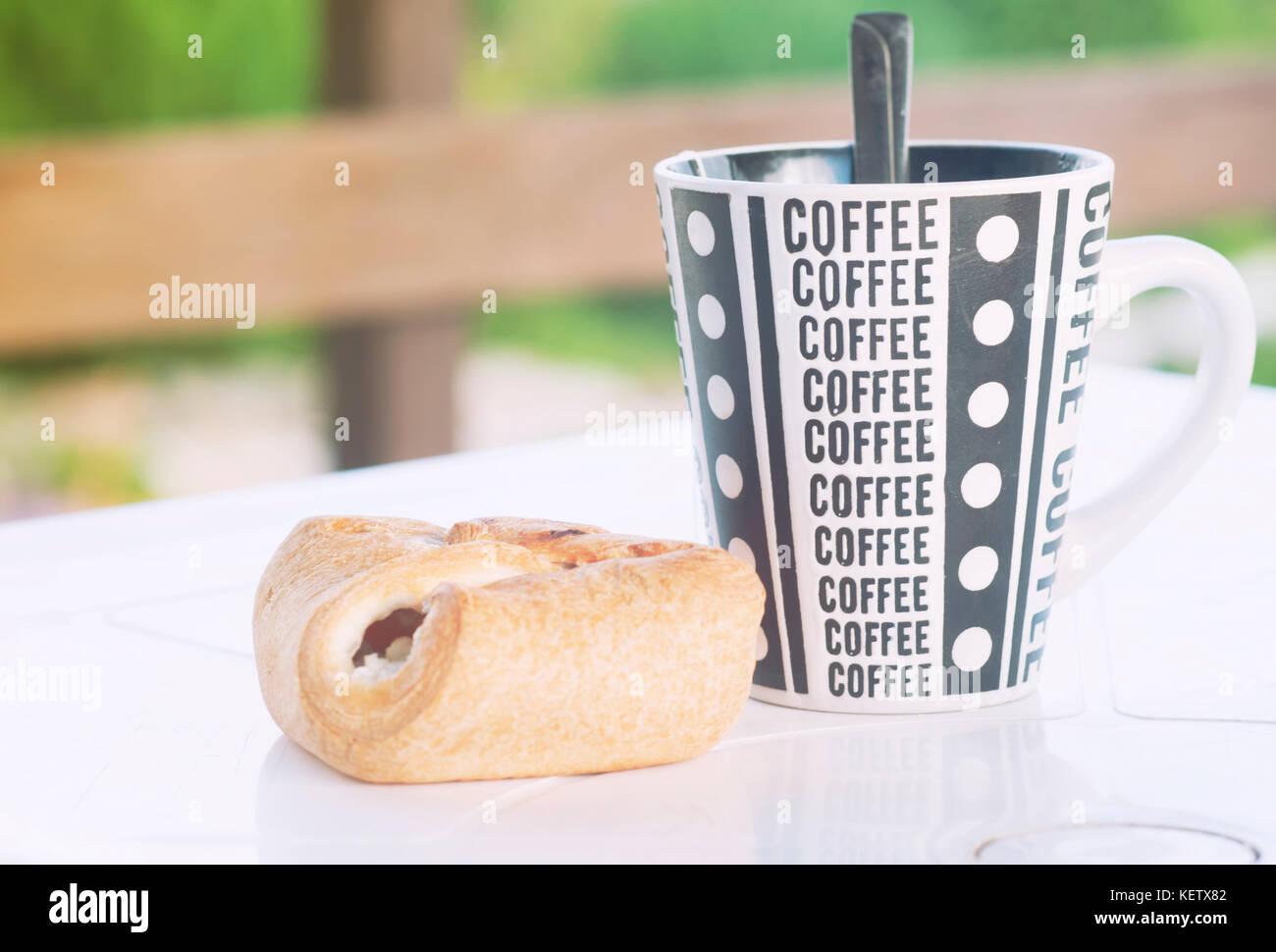 Una tazza di caffè con un cornetto sul tavolo, la veranda di una casa di campagna, un tonico foto Foto Stock