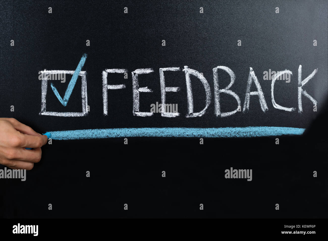 Close-up di persona a mano che mostra il concetto di feedback scritti sulla lavagna Foto Stock