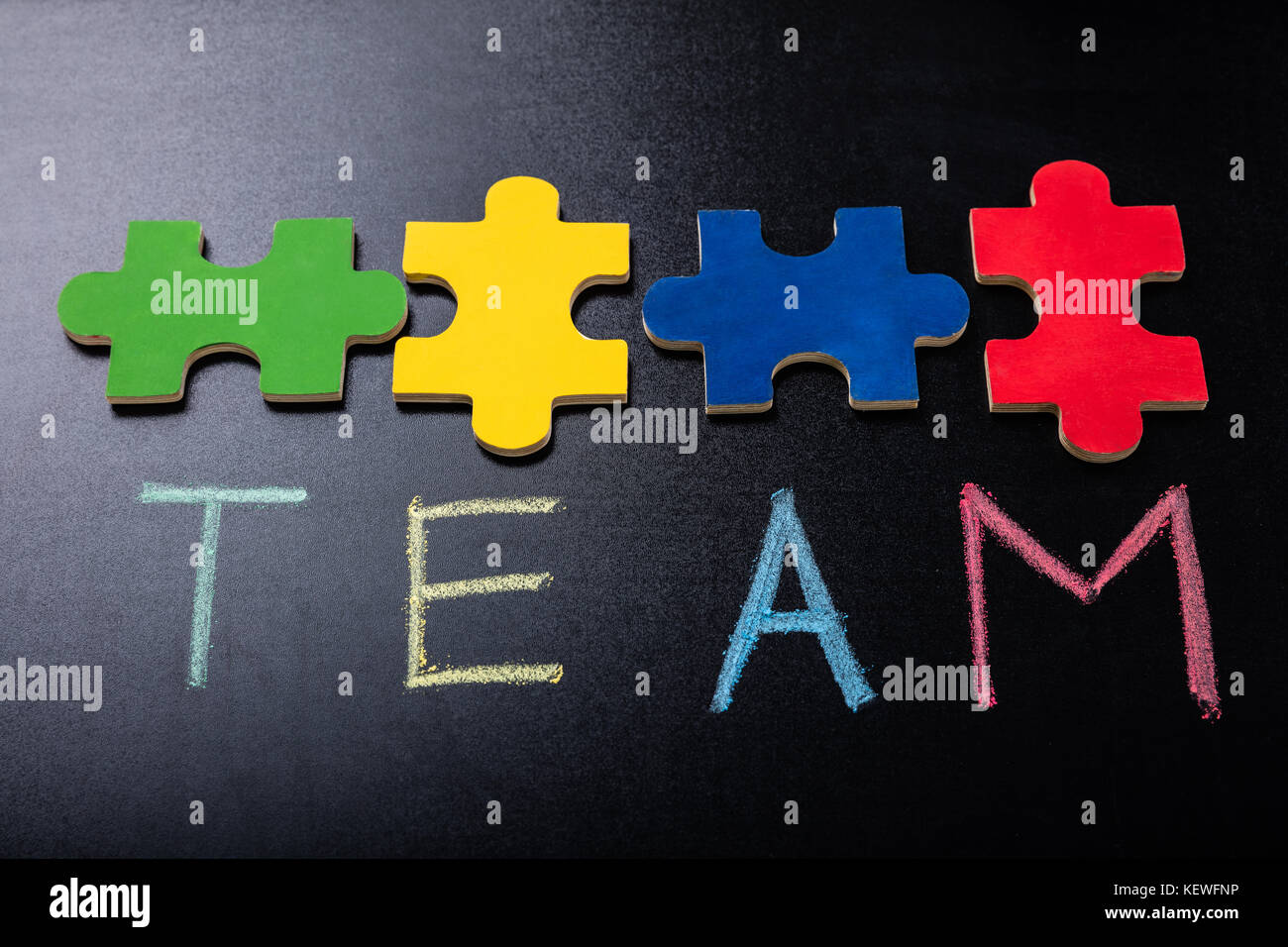 Puzzle Jigsaw colorato pezzo con testo squadra su Blackboard Foto Stock