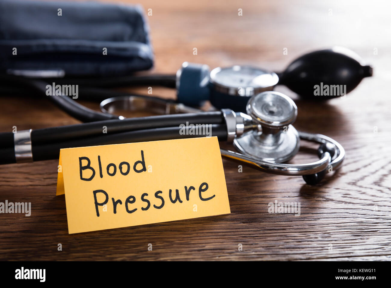 Uno sfigmomanometro e stetoscopio con la pressione sanguigna concetto sulla scrivania in legno Foto Stock