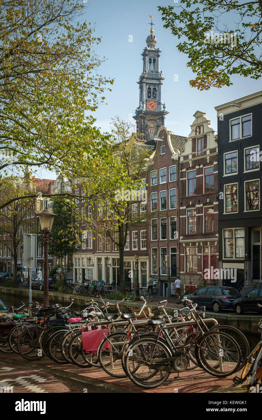 La inclinazione westertoren torreggia sopra lato canale case nel quartiere di Jordaan, Amsterdam. Foto Stock
