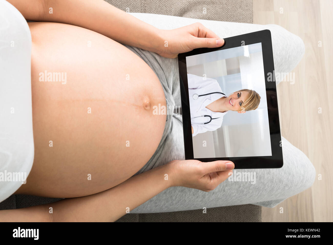 Close-up della donna incinta la videoconferenza con medico sul computer portatile Foto Stock
