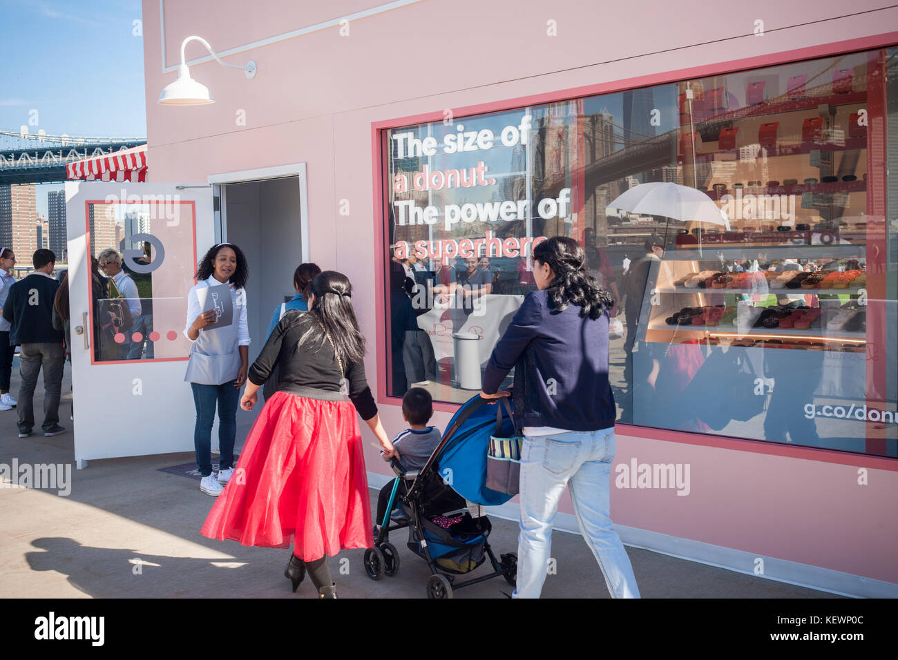 Centinaia di linea fino a visitare la home page di Google mini pop-up 'donut shop' nel ponte di Brooklyn Park a New York sabato, 21 ottobre 2017. Dopo aver atteso sulla linea fino a un'ora e mezza, i visitatori sono stati trattati due ciambelle libero ed è entrato in una possibilità di vincere un rilasciato recentemente home page di Google mini che coincidently è la dimensione e la forma di una ciambella. (© richard b. levine) Foto Stock