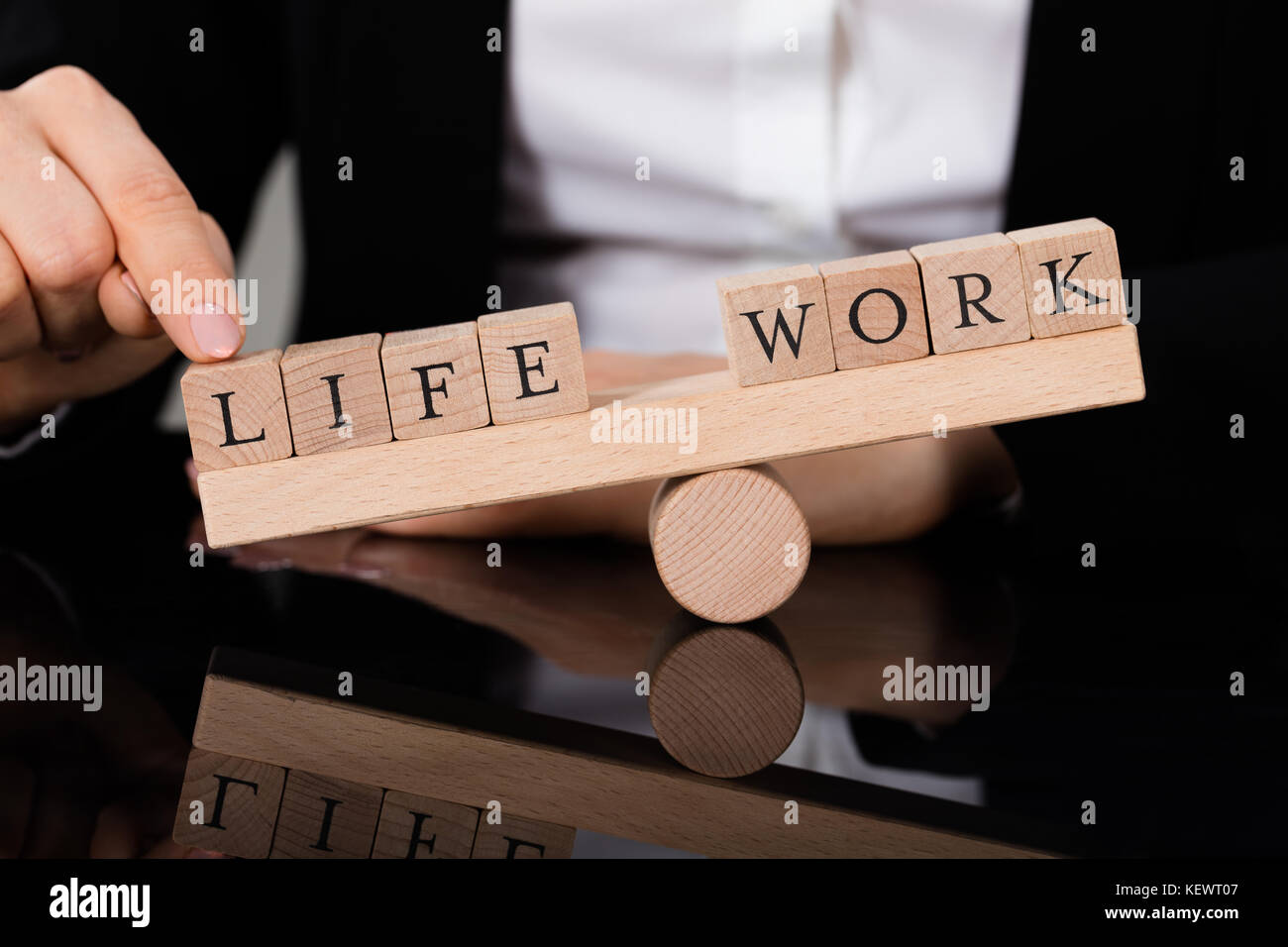 Close-up di una persona che mostra uno squilibrio tra la vita e il lavoro su altalena Foto Stock