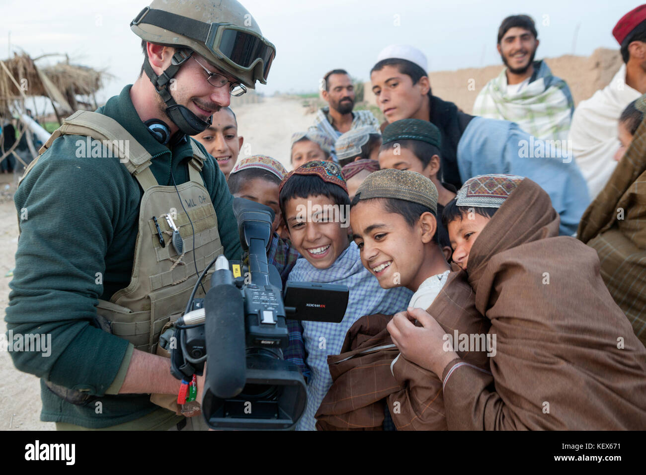 Una telecamera man show bambini afgani le immagini sulla sua fotocamera, provincia di Helmand, Afghanistan Foto Stock