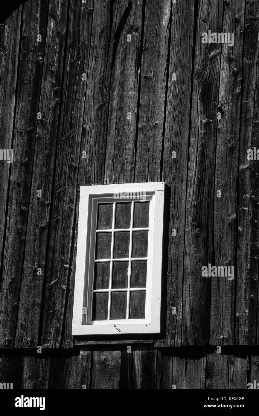 Finestra bianca a lato di un fienile in legno. Immagine in bianco e nero. Foto Stock