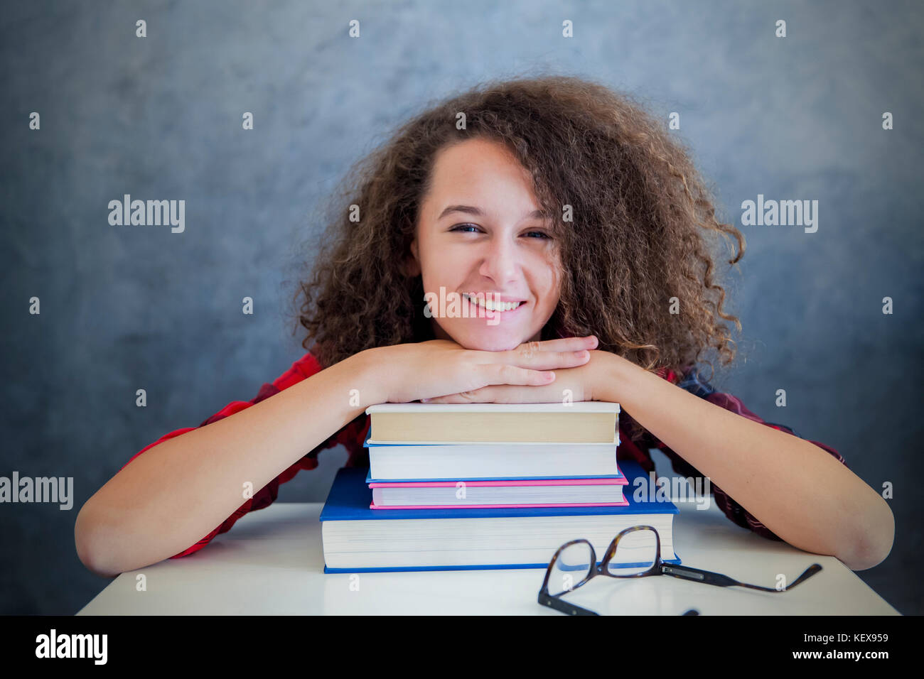 Ritratto di capelli ricci teen ragazza resto dall'apprendimento sui libri Foto Stock