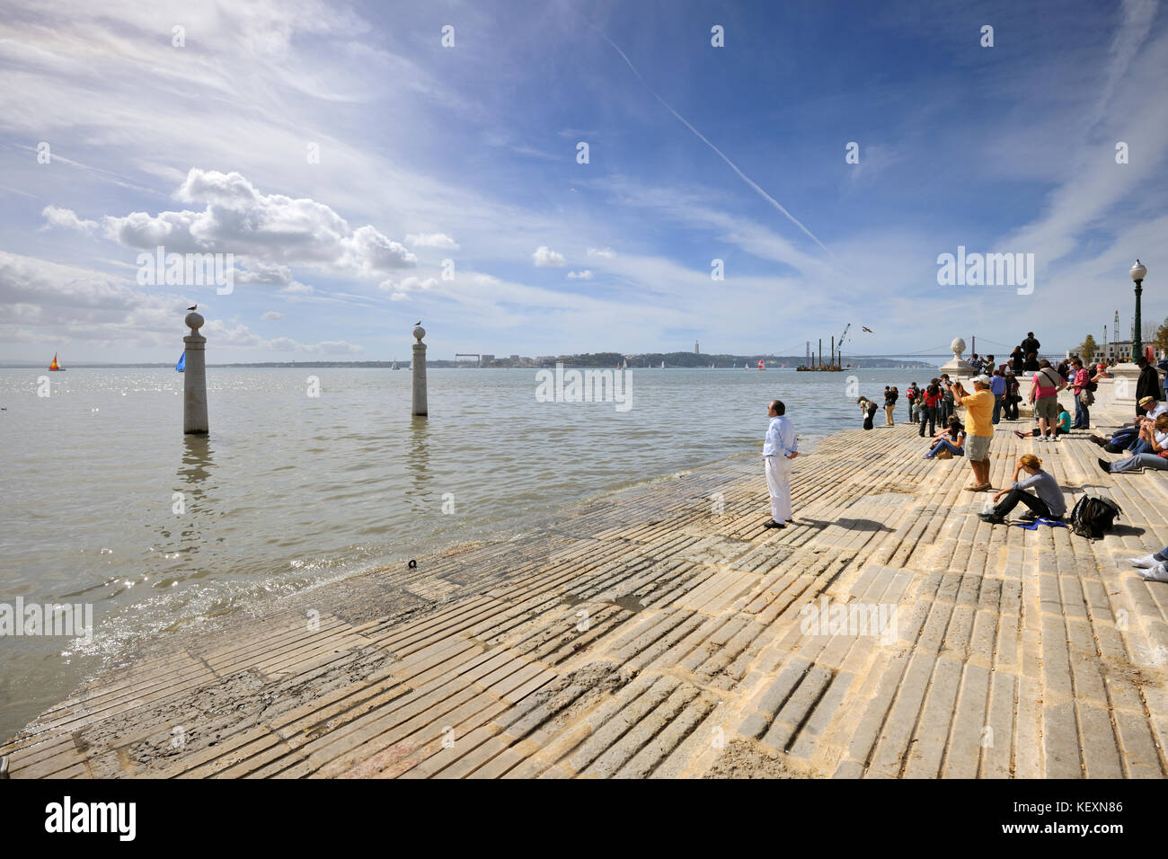 Uomo solitario di fronte al fiume Tago. Cais das Colunas, Lisbona, Portogallo Foto Stock