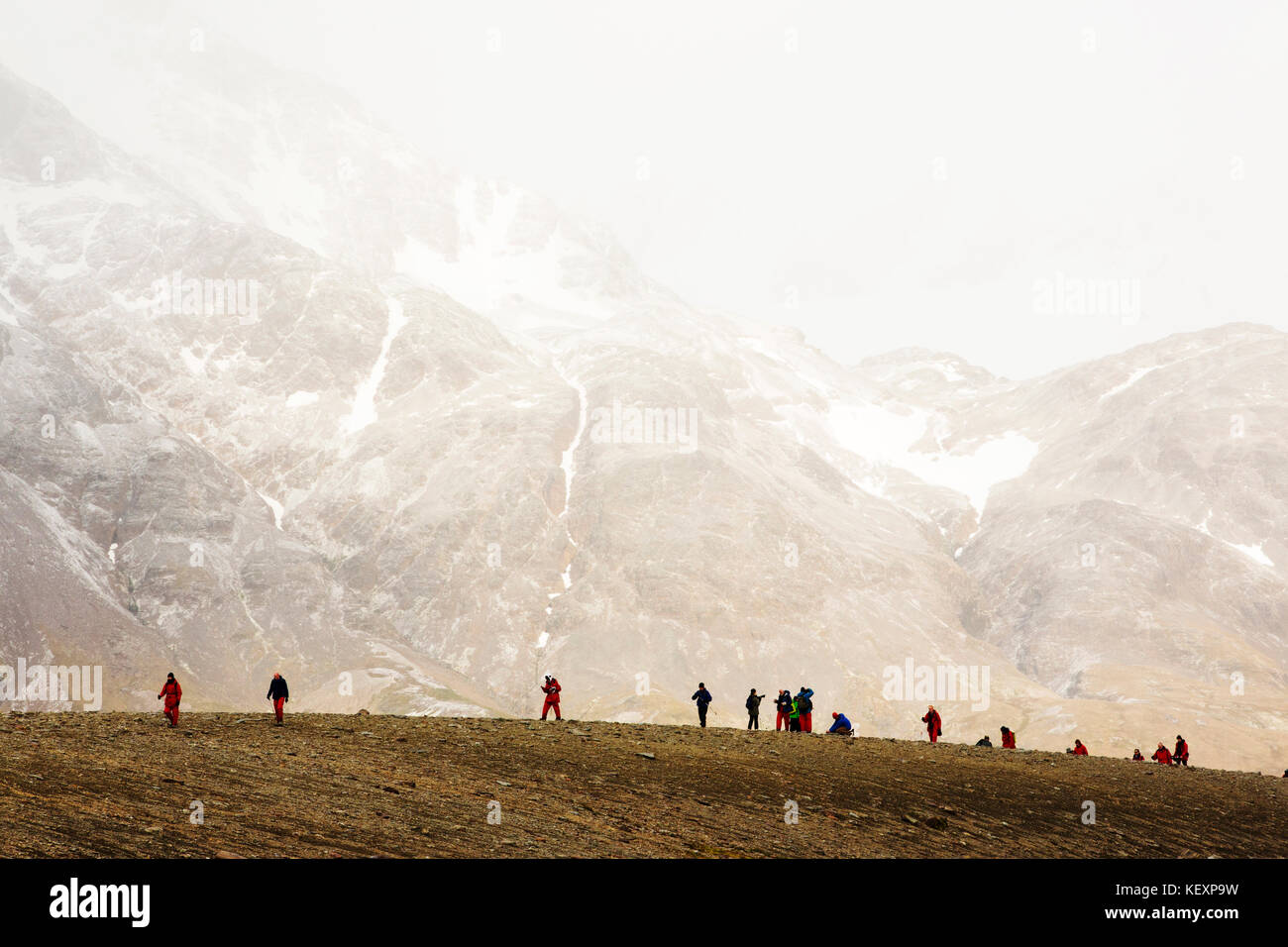 I passeggeri di un expedition cruise per Anarctica recreat parte di Shakleton la famosa passeggiata attraverso Georgia del Sud. Il gruppo sono a piedi dalla Fortuna Bay a Stromness. Foto Stock