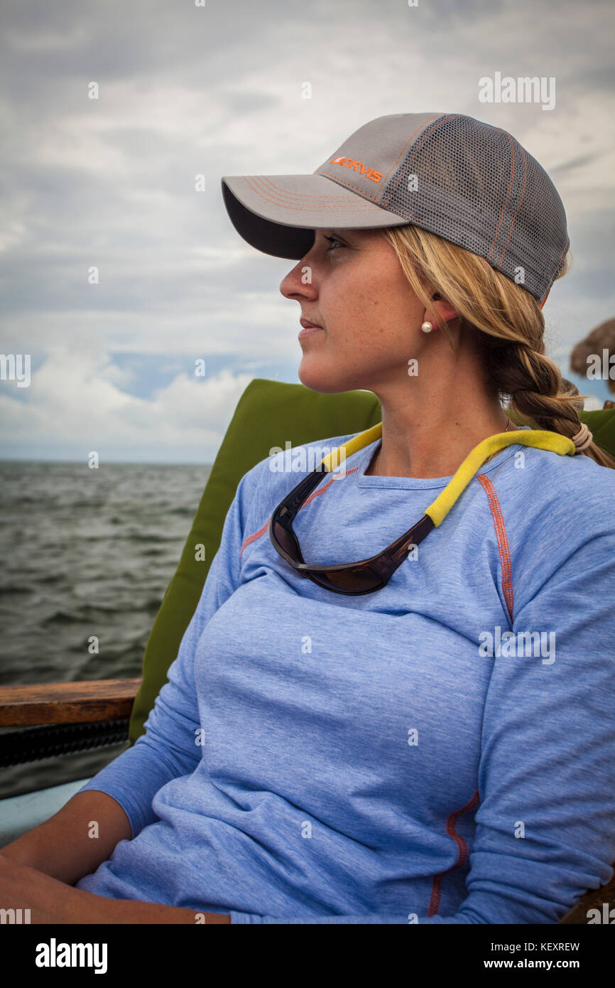 Fotografia della donna nel cappello da baseball seduti in barca, Ambergris Caye Belize Foto Stock
