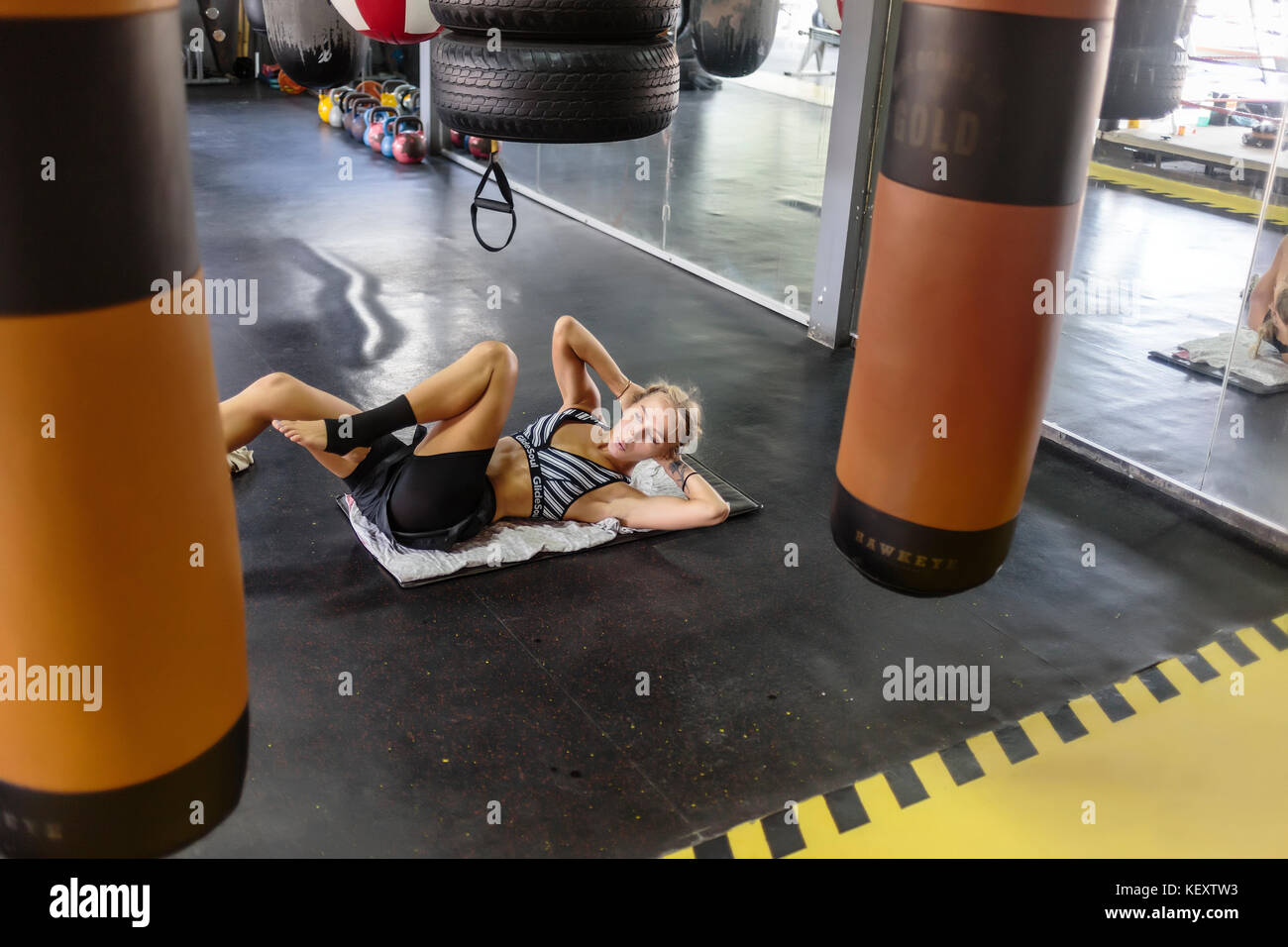 Fotografia della giovane donna in palestra facendo sit ups, Seminyak Bali, Indonesia Foto Stock