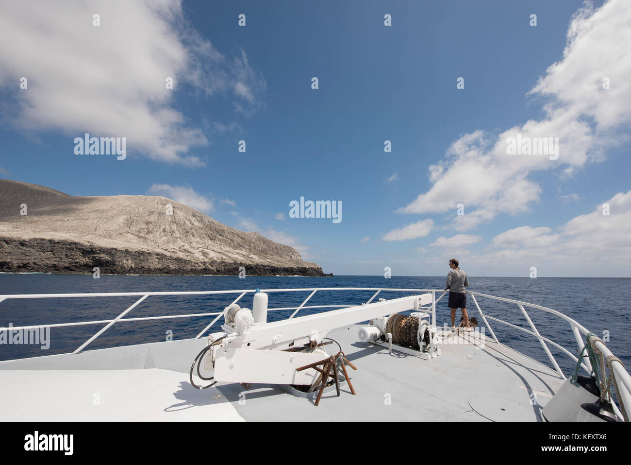 Fotografia di un singolo uomo che guarda la vista dell'isola di San Benedicto dalla nave, le isole Revillagigedo, Colima, Messico Foto Stock