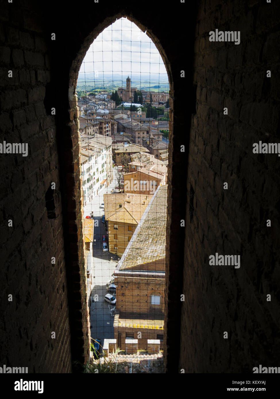 Vista verso la chiesa di santa maria dei servi tramite lancetta finestra nella torre del Mangia a Siena, Toscana, Italia Foto Stock