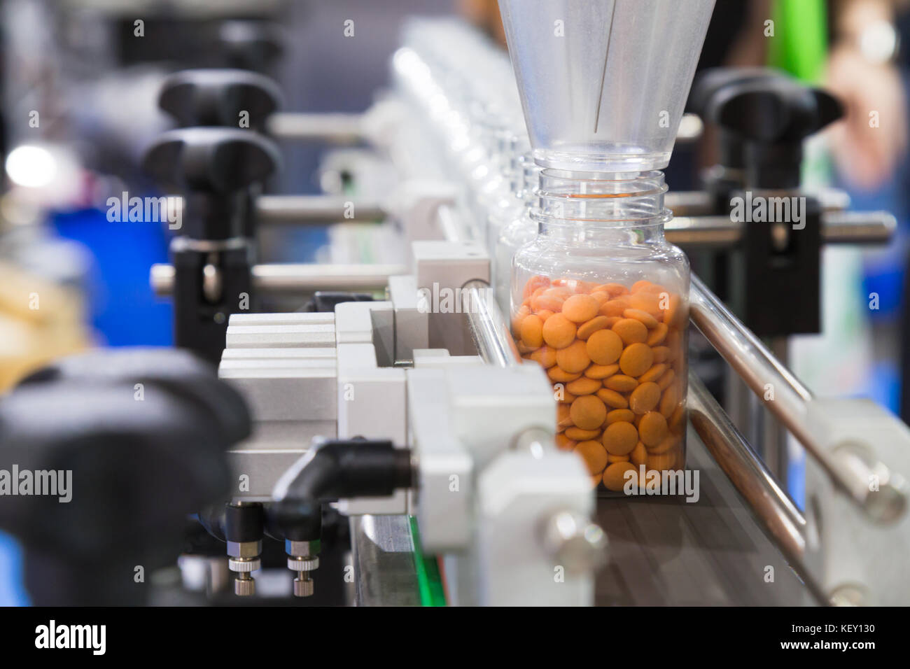 Industria farmaceutica, medicina pillole sono il riempimento della bottiglia di plastica sulla linea di produzione trasportatore di macchina presso il medico di fabbrica. Il fuoco selettivo. Foto Stock