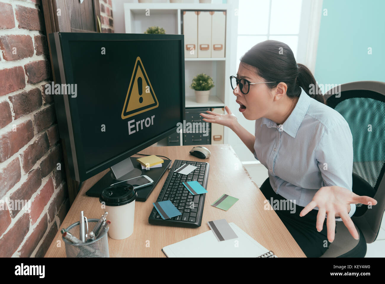 Tristezza lavoratore di ufficio lady mostra confuso in posa e guardare il computer le informazioni di errore perché lei tutta la carta di credito dopo aver rubato. Foto Stock