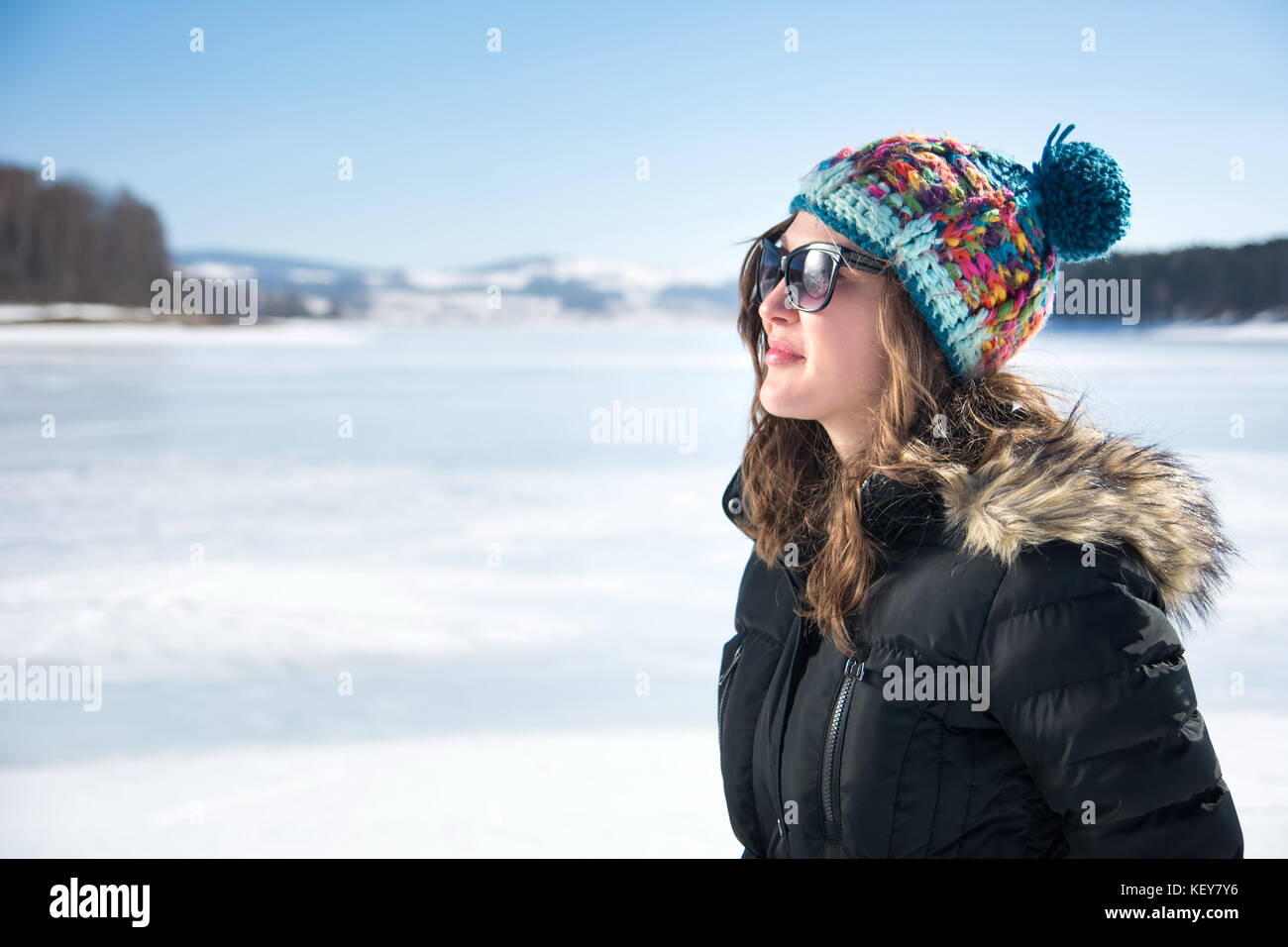 Ragazza su un lago ghiacciato su una soleggiata giornata invernale Foto Stock