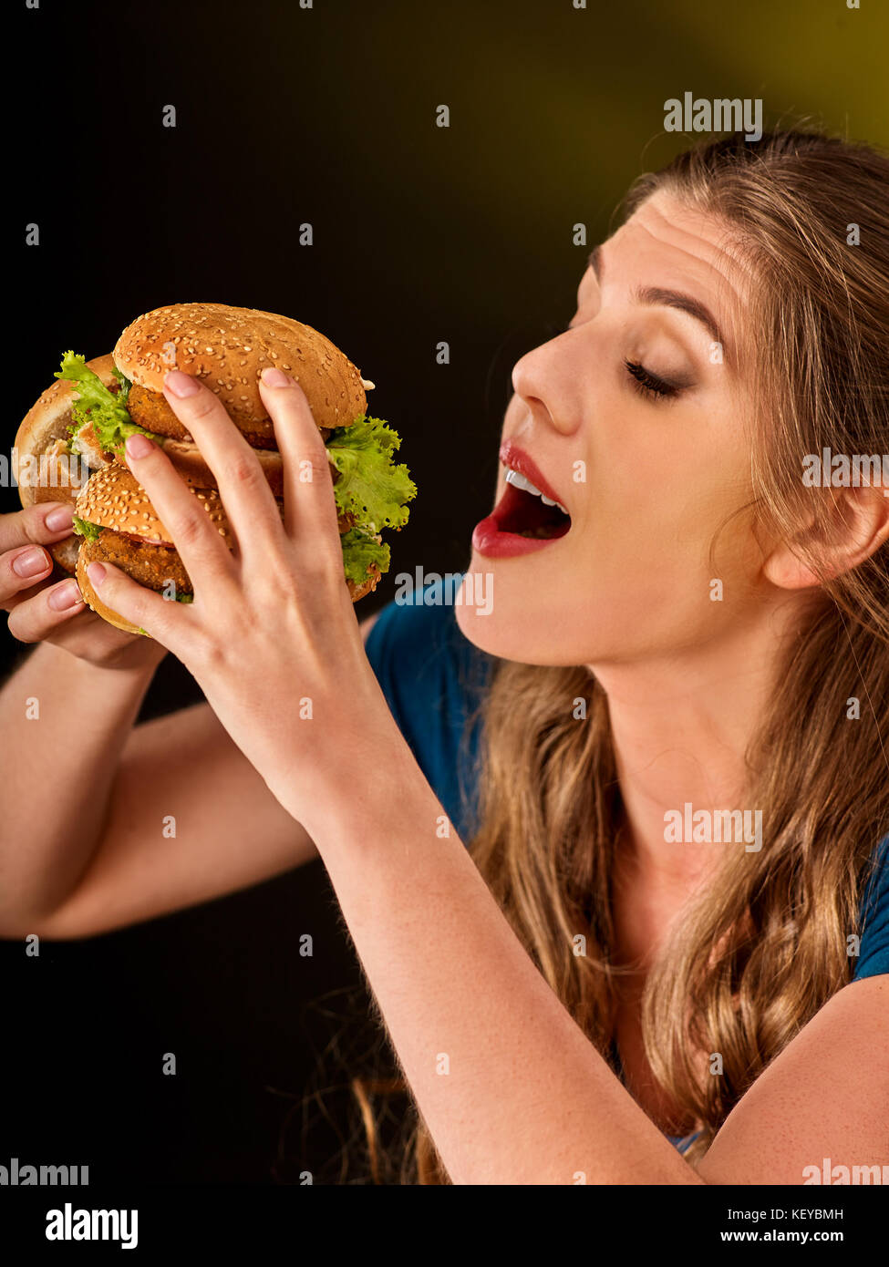 Ragazza mangiare grandi hamburger. un fast food concept. Foto Stock
