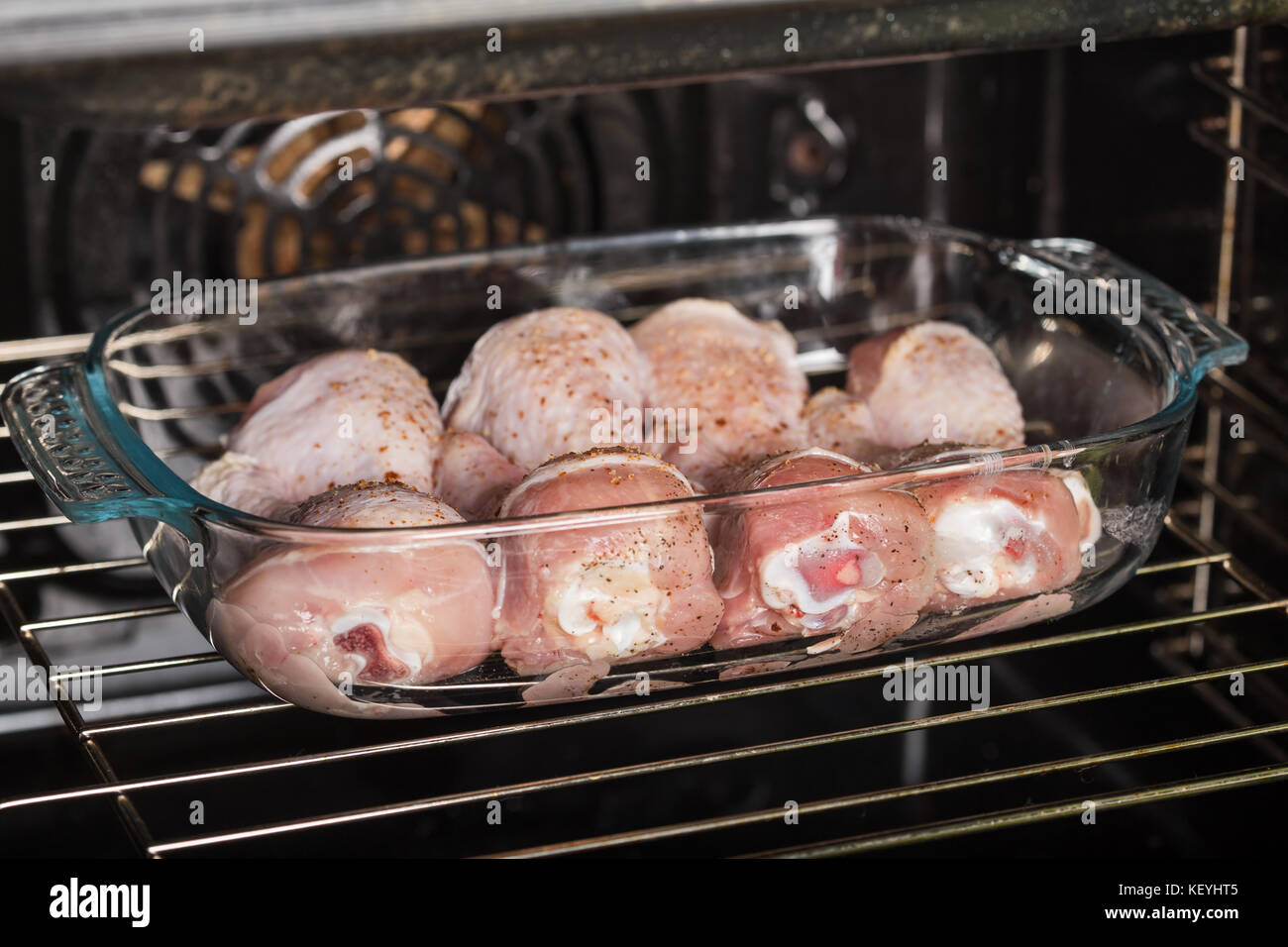 Le cosce di pollo sono cotti in forno in una forma di vetro Foto Stock