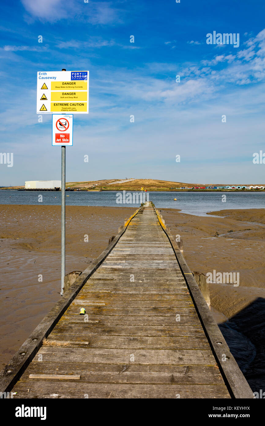 Un pontile in legno che si allunga nel fiume Tamigi con la bassa marea, sull'altro lato del fiume è Rainham discarica in Essex, Erith, London, Regno Unito Foto Stock