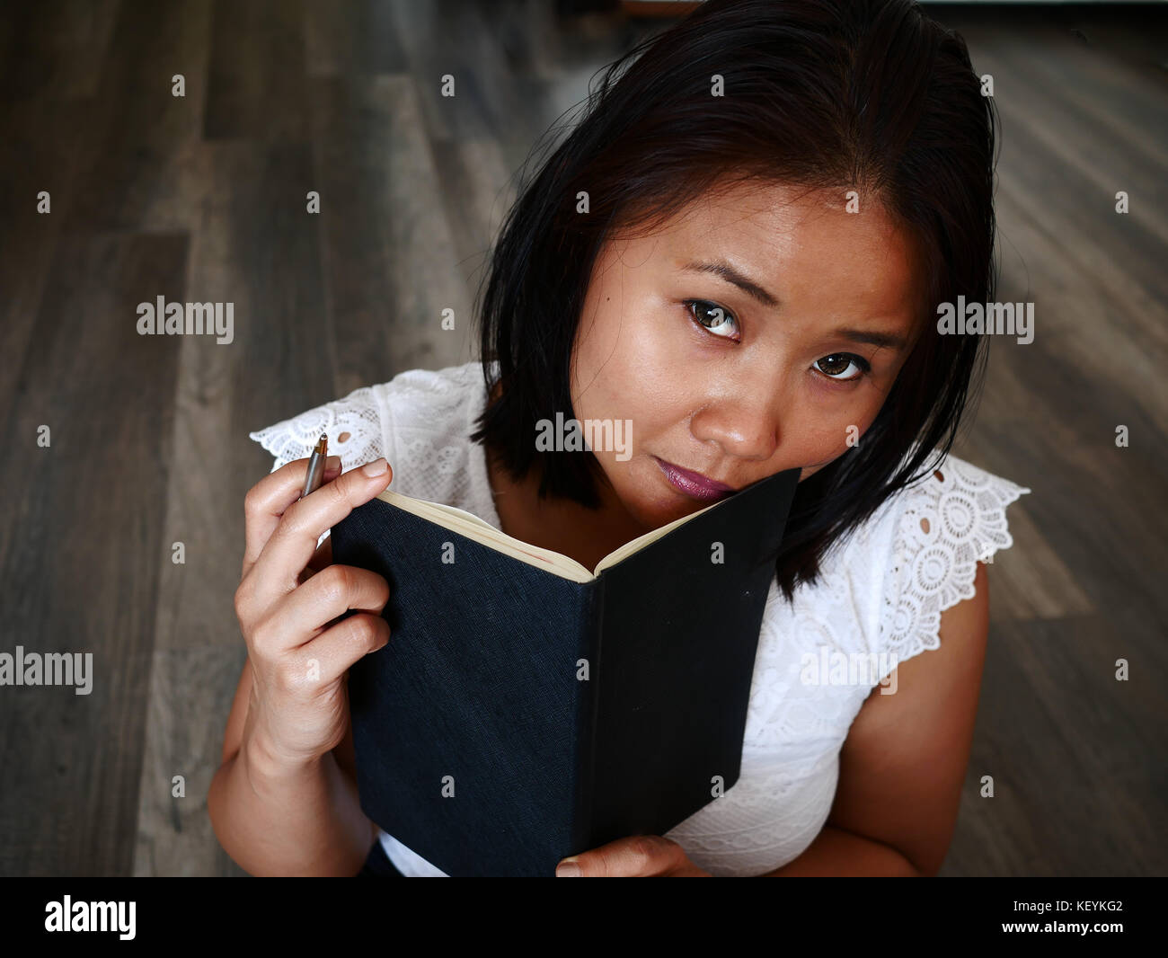 Donna che mantiene un notebook e una penna, piallatura per scrivere Foto Stock