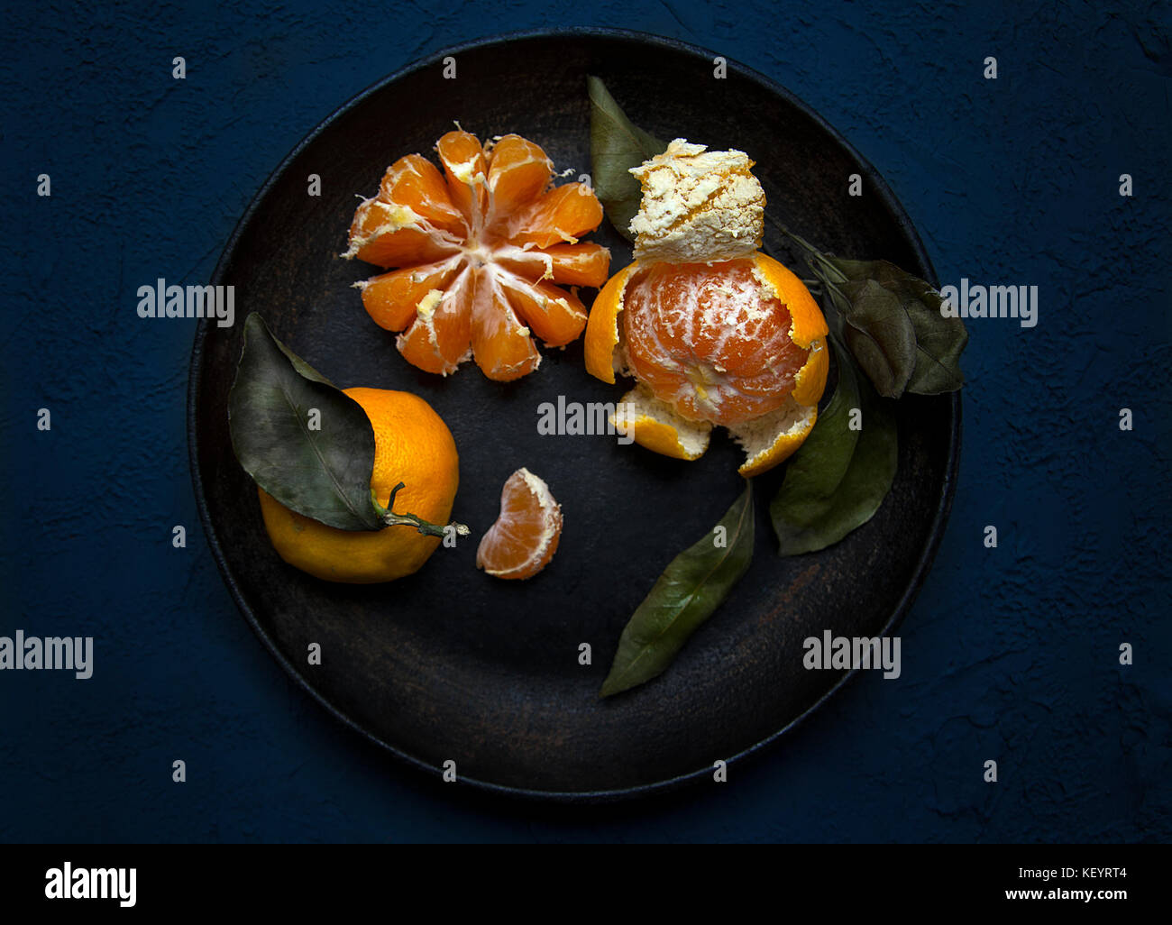 Mandarini con foglie in una padella vintage Foto Stock