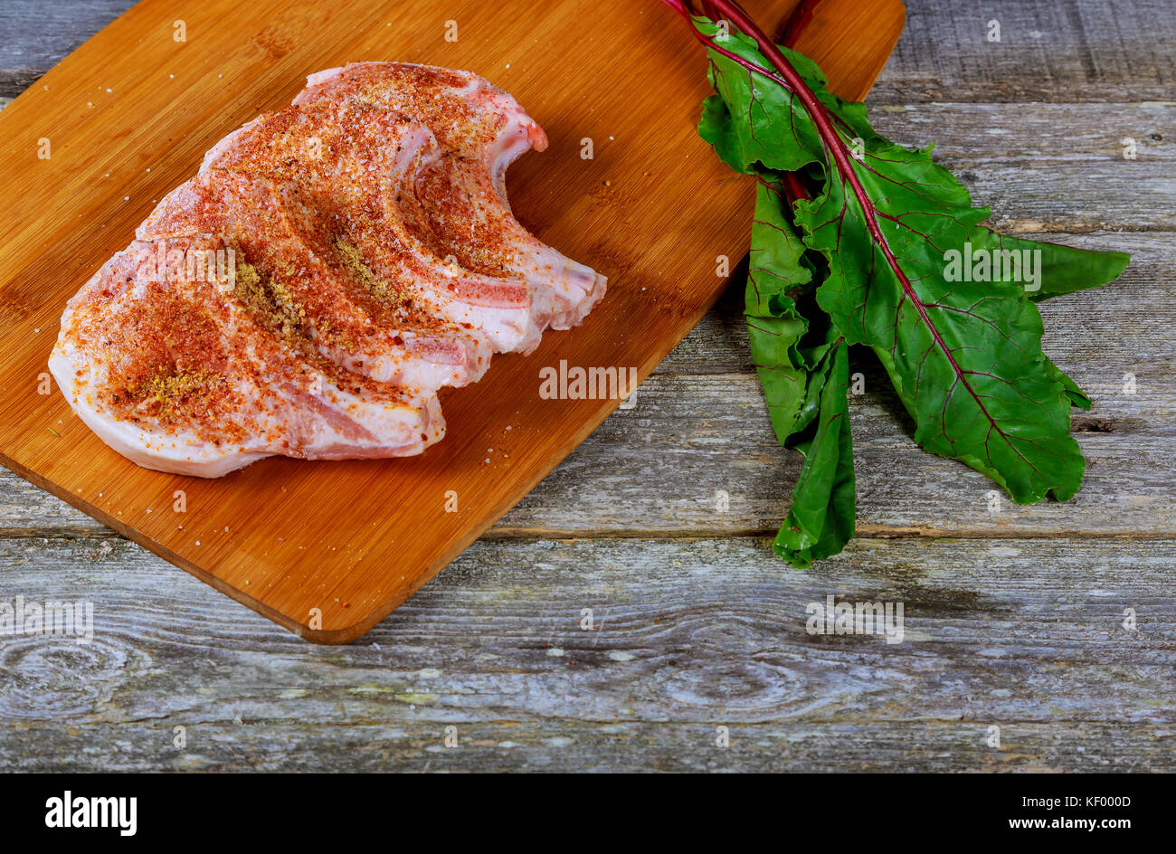 Aw bistecca di carne sul legno scuro scheda. Sottili fette di carne di maiale Foto Stock