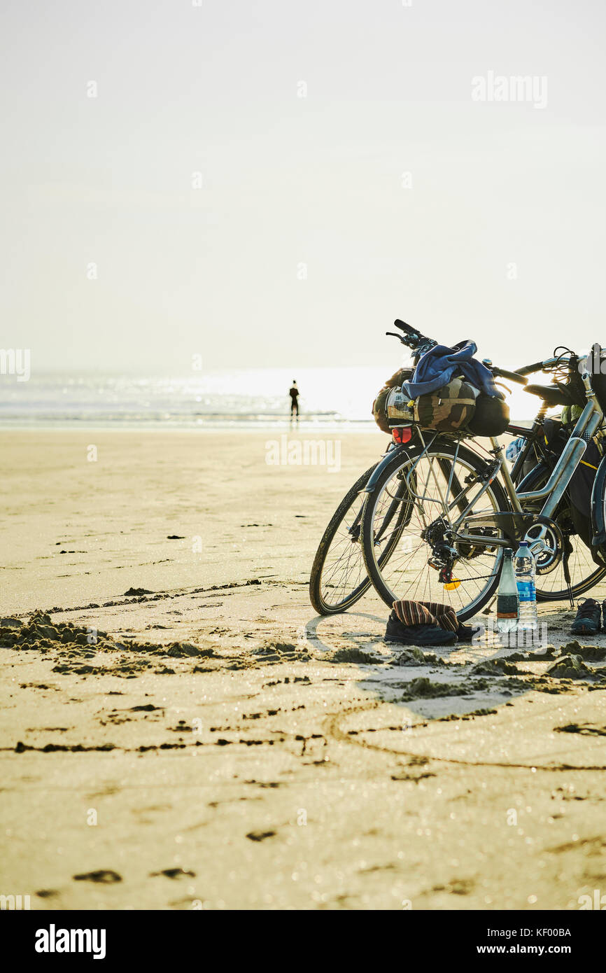 Due biciclette parcheggiate sulla spiaggia in Finisterre Francia. Foto Stock