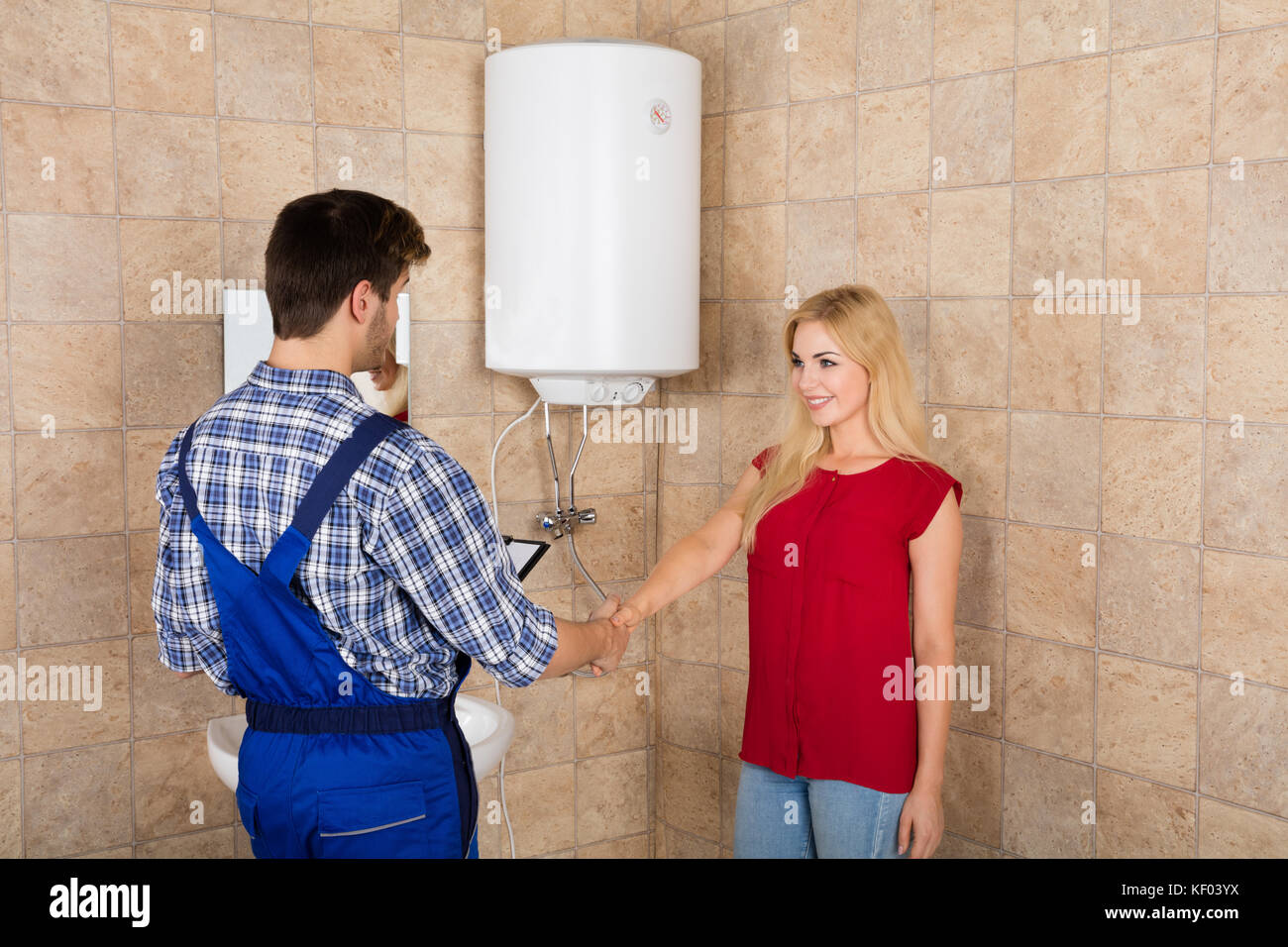 Giovane donna si stringono la mano con connettore maschio di tipo idraulico  in bagno a casa Foto stock - Alamy