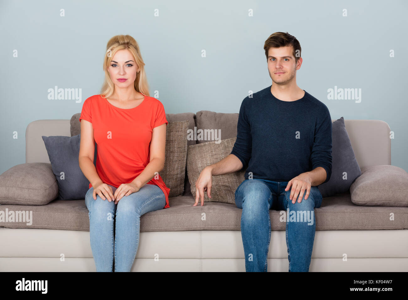 Uomo timido seduto sul divano Flirting con Donna a casa Foto Stock