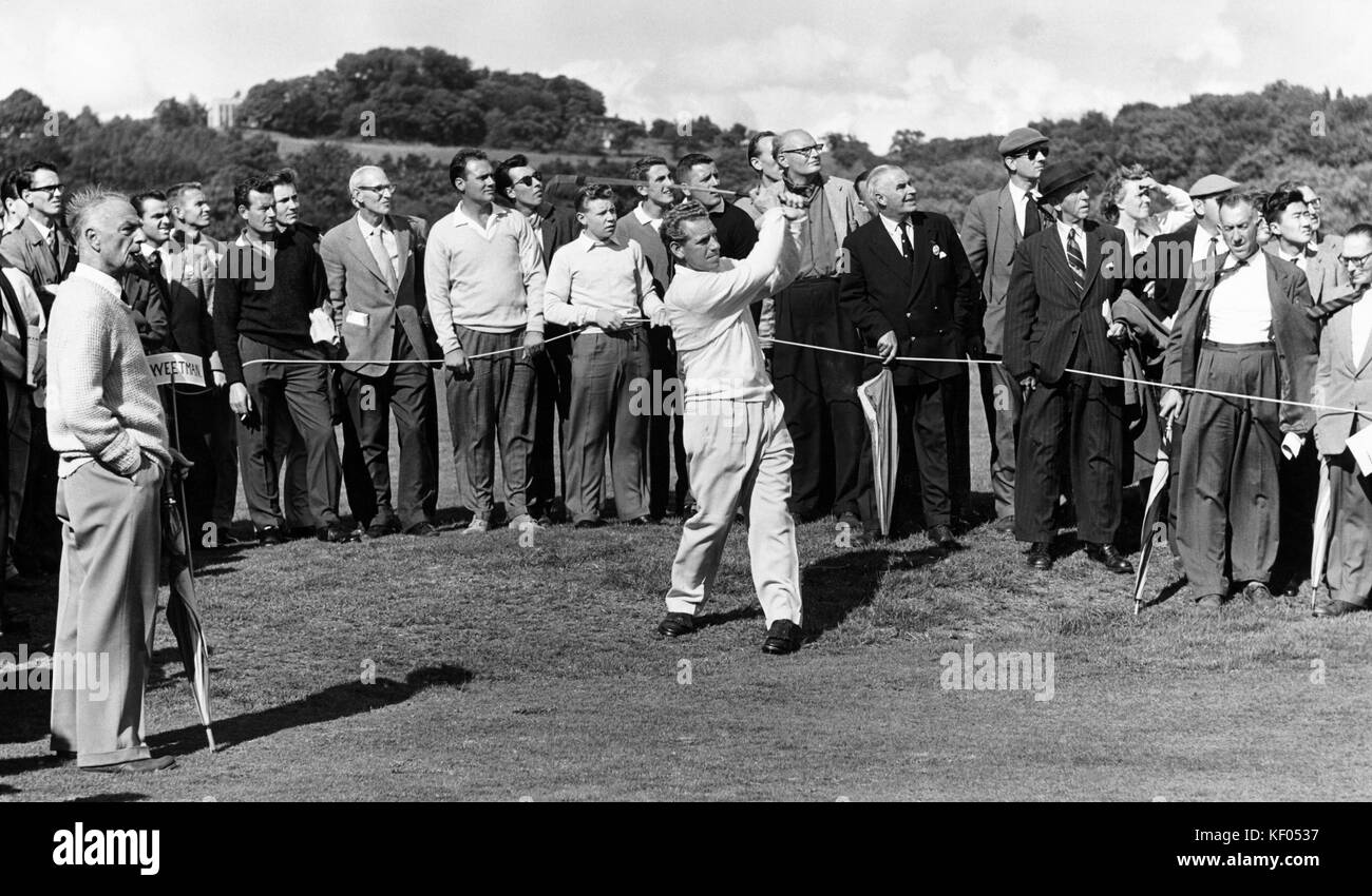 Un golfista professionista in pieno svolgimento durante un torneo di golf su un unidentified - corso di inglese. Un caddy, a sinistra, è in possesso di un cartello che diceva "[S]wee Foto Stock