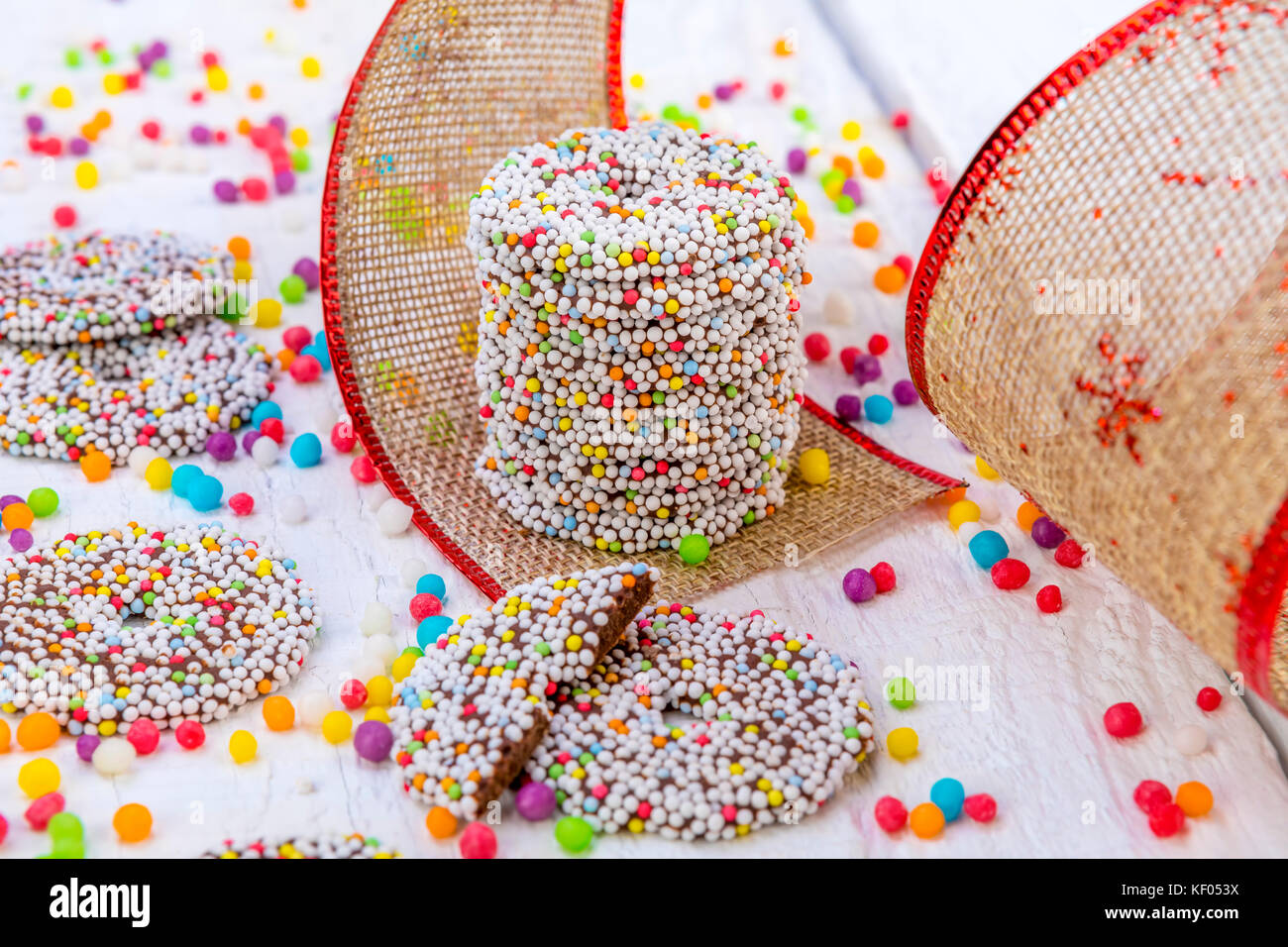 Cioccolato colorato anelli con decorazione di Natale in bianco sullo sfondo di legno Foto Stock