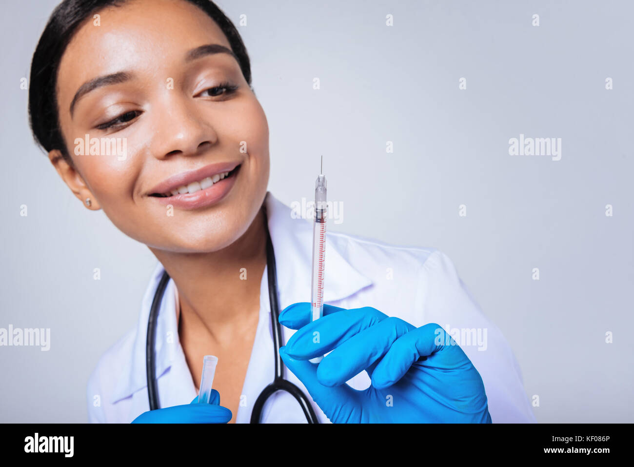 Close up di sorridere medico donna tenendo la siringa Foto Stock