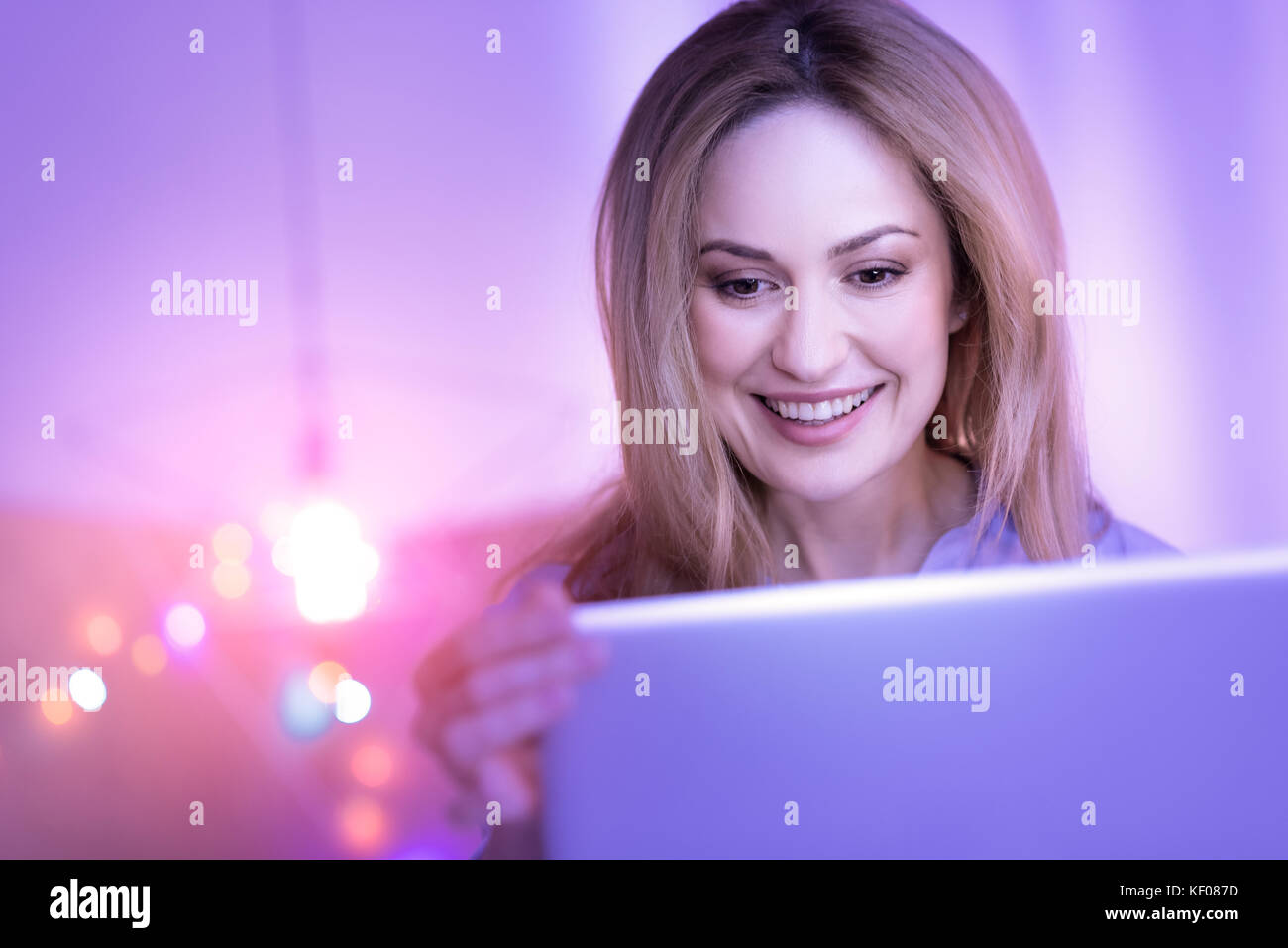 Signora esuberante lavorando sul suo computer portatile Foto Stock