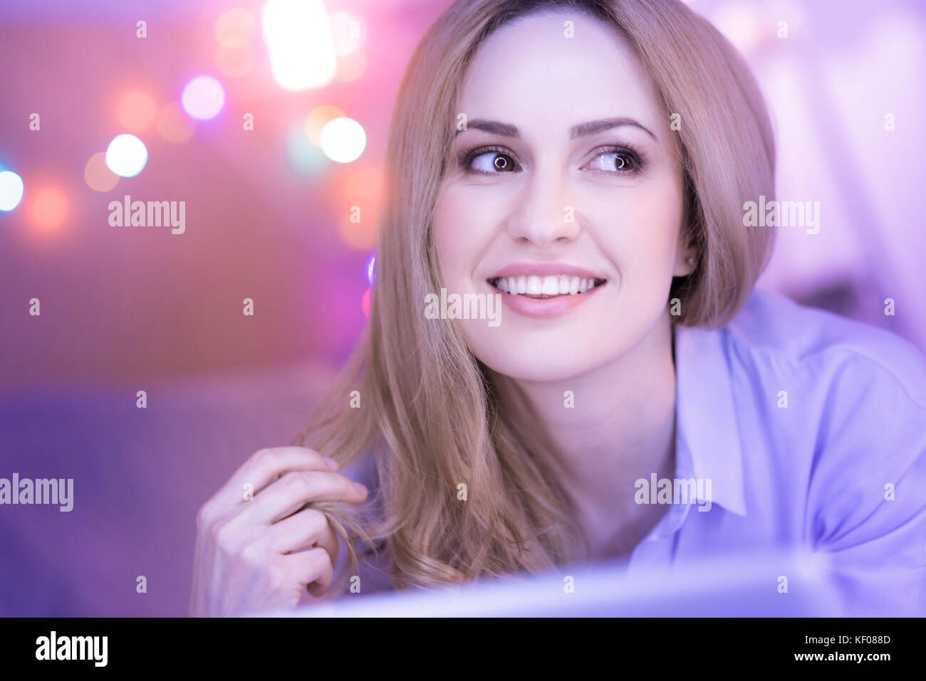 Energica signora sorridente a giocare con i suoi capelli Foto Stock