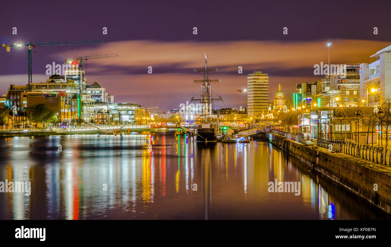 Dublino, Irlanda, vista notturna di Samuel Beckett Bridge per Jeanie Johnston Tall Ship contro lo sfondo di Sean O'Casey ponte sopra il fiume Lif Foto Stock