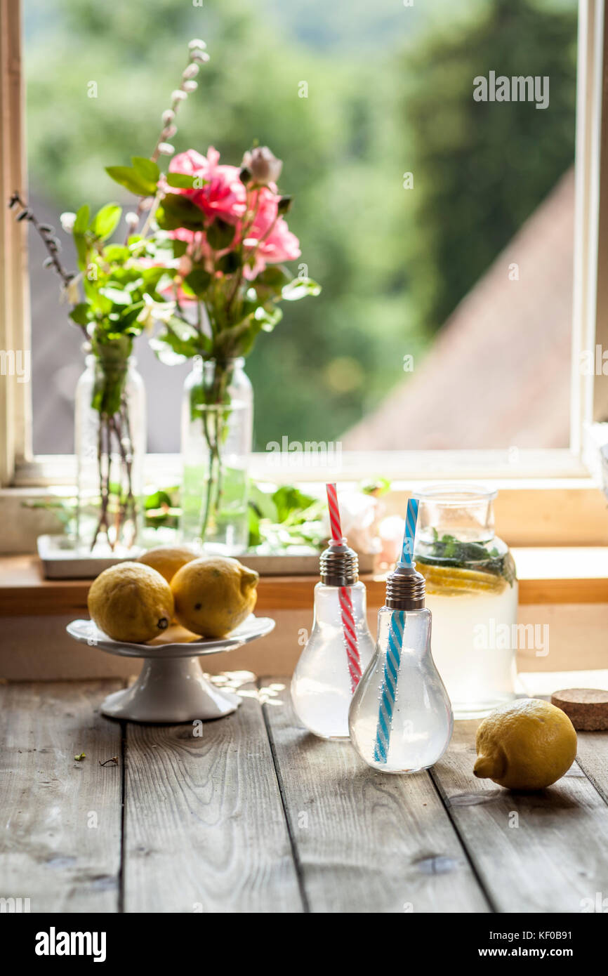 Limonata fatta in casa con la menta sul tavolo in legno nella parte anteriore della finestra Foto Stock