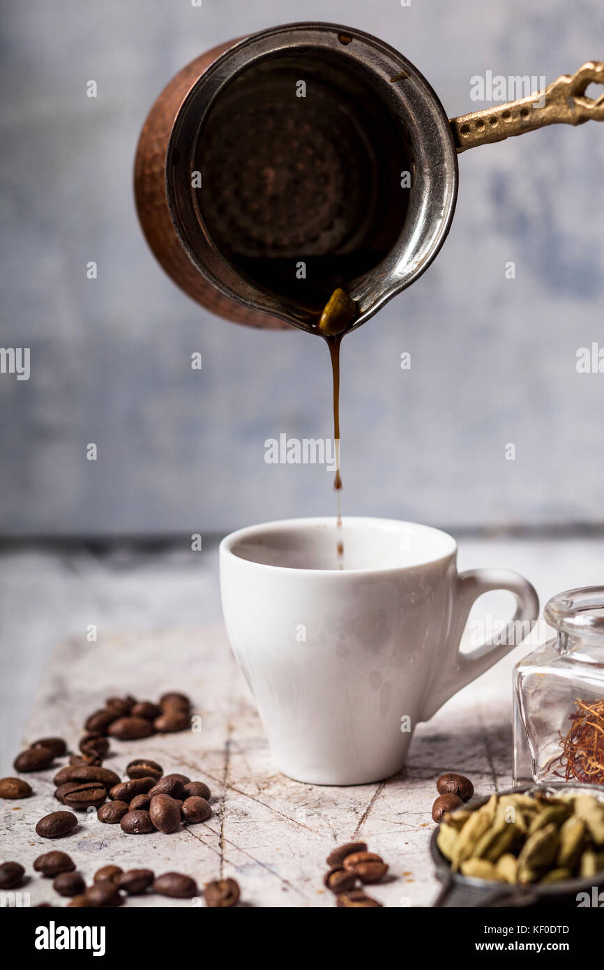 Versando arabian caffè in tazza Foto Stock