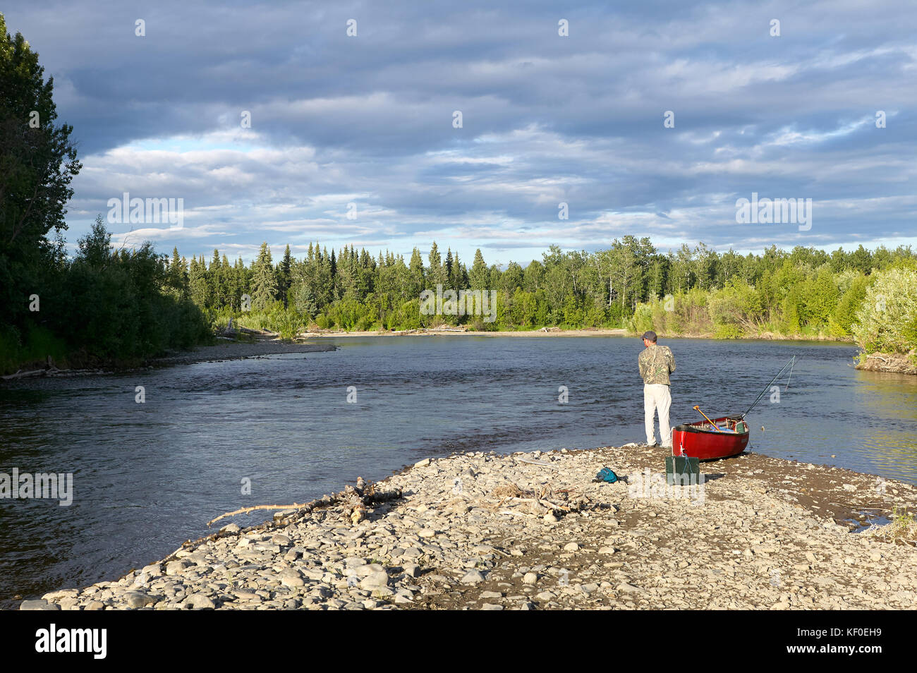 Kayaker e kayak sulla riva del fiume kipchuk in Alaska in un paesaggio incontaminato con il verde dei boschi e acque calme Foto Stock