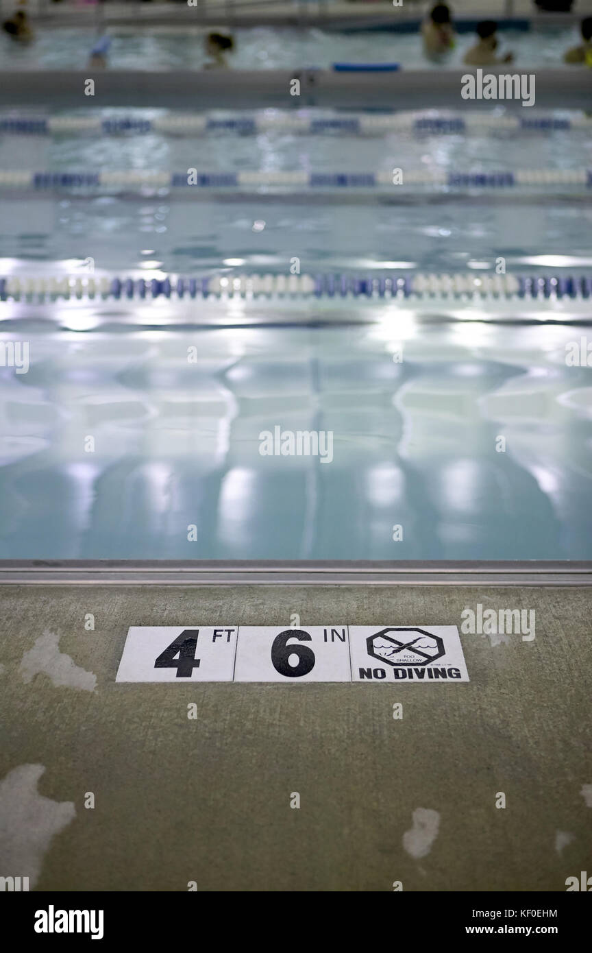 Profondità di avvertimento Restrizione sulla pavimentazione in corrispondenza di un bordo di una piscina a 4 piedi 6 pollici che vieta le immersioni Foto Stock