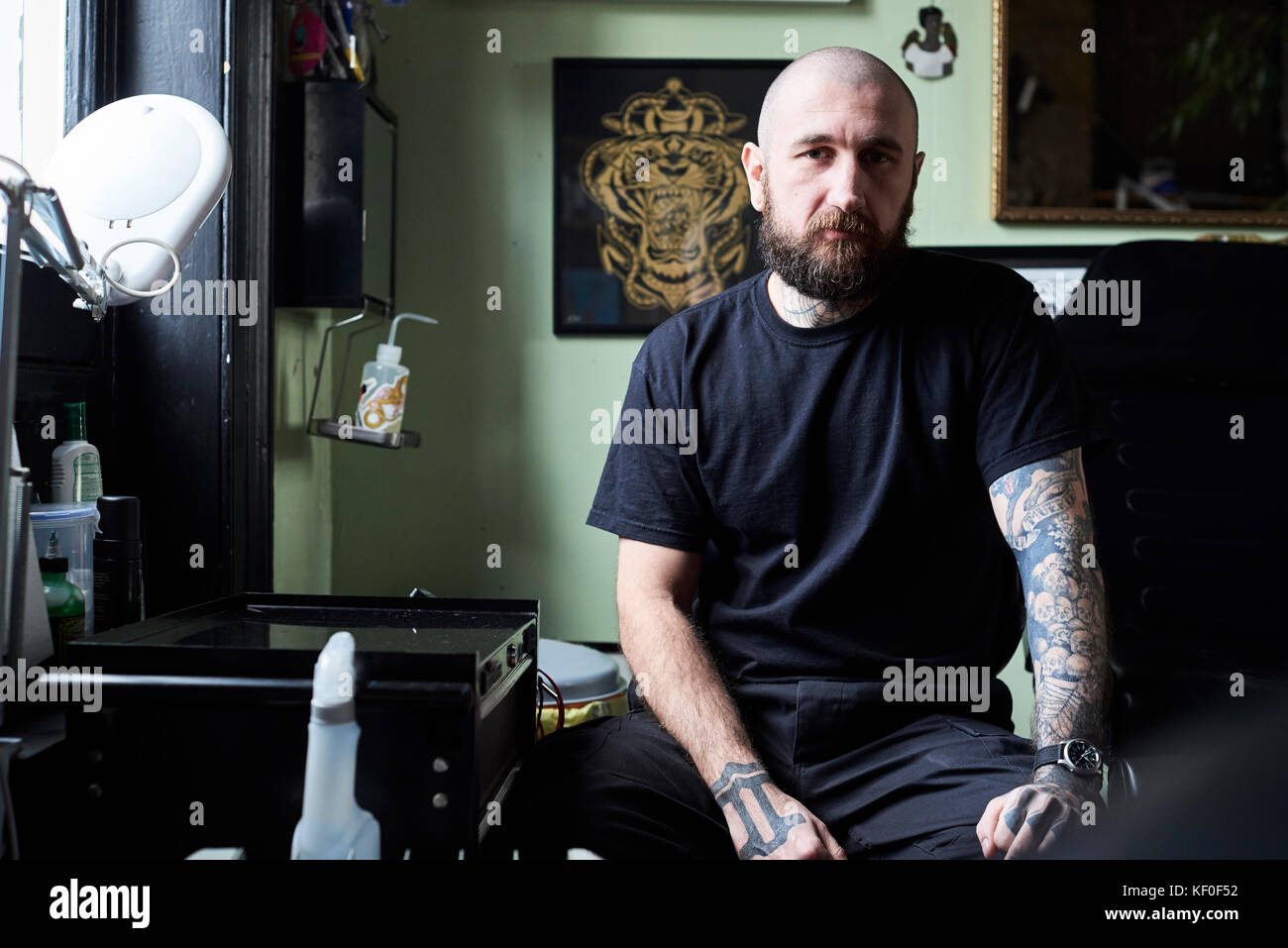 Londra, UK, Ritratto di un tatuaggio artista al lavoro nel suo locale commerciale studio, tattooist Foto Stock