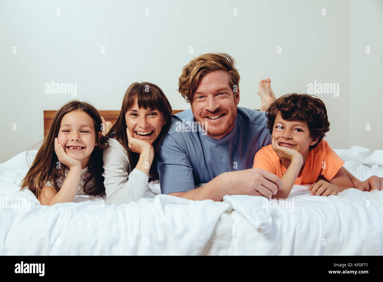 Ritratto di genitori e i loro figli a letto Foto Stock