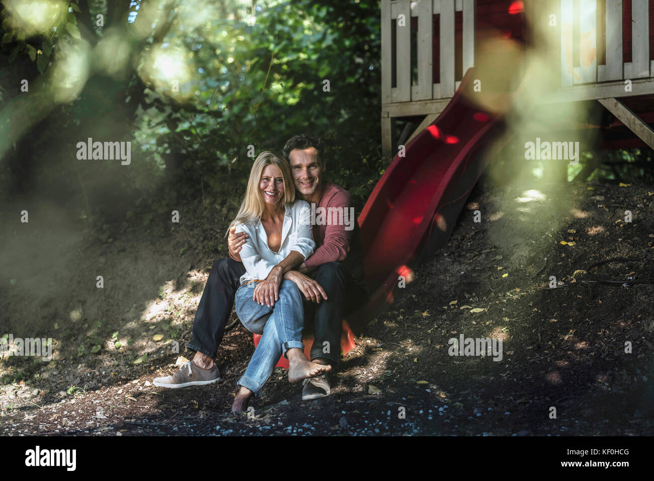 Felice coppia seduta sulla slitta della Tettoia da giardino nel bosco Foto Stock