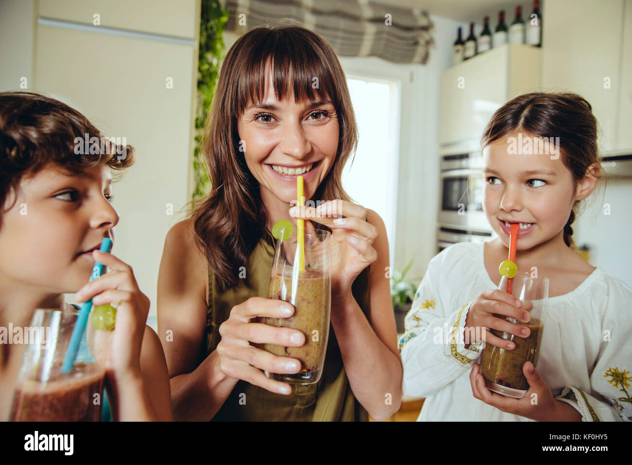 Madre e figli godendo il loro frullati fatti in casa Foto Stock