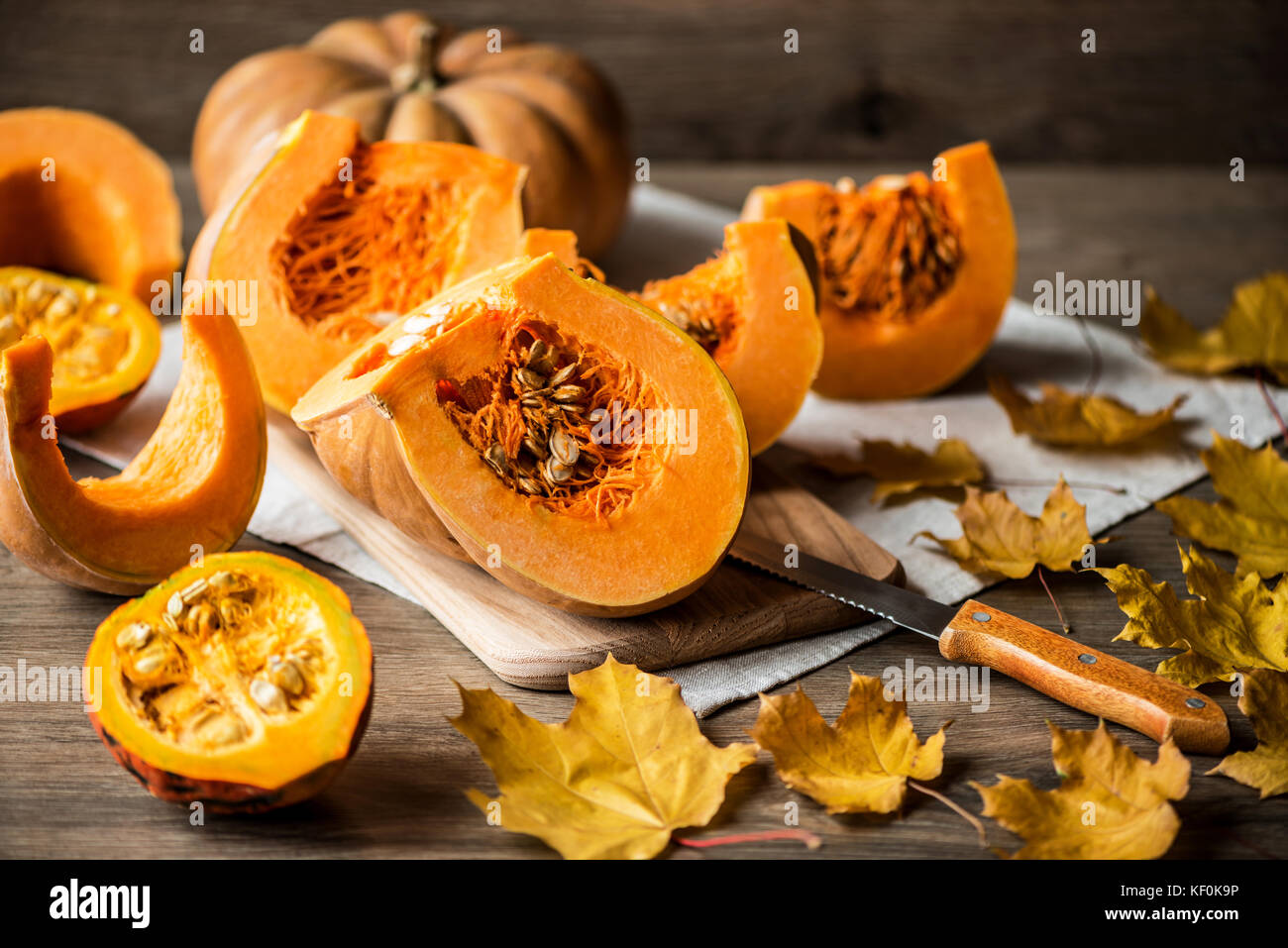 Fette di zucca con semi su un sfondo di legno. close-up Foto Stock