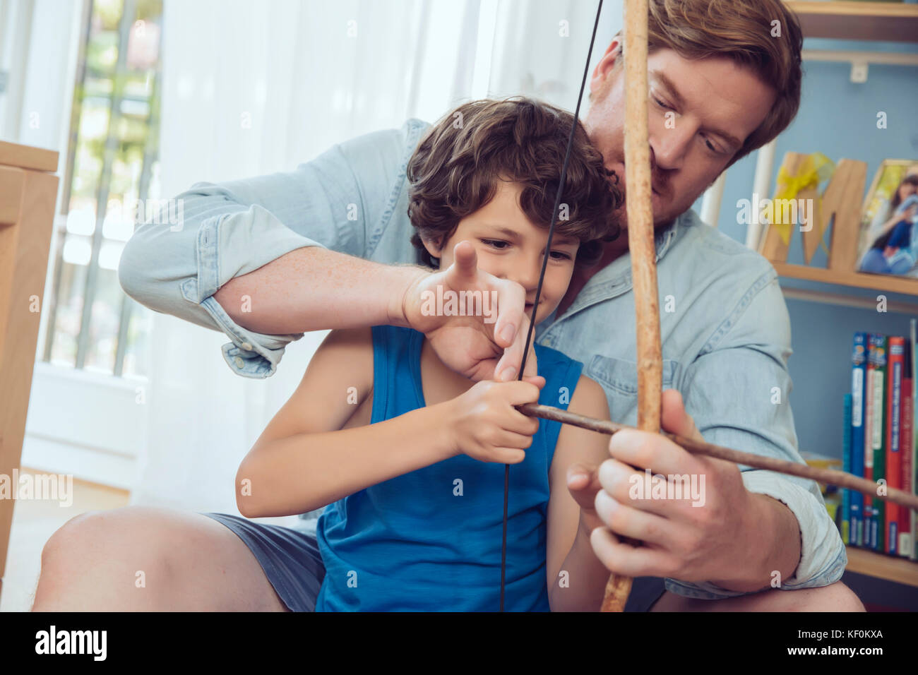 Padre figlio che mostra come utilizzare self-made arco e frecce Foto Stock
