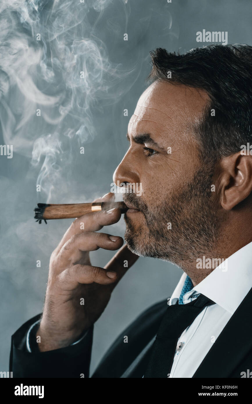 Imprenditore di fumare il sigaro Foto Stock