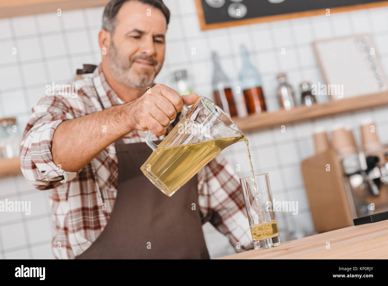 Barista versando il succo di mela in vetro Foto Stock